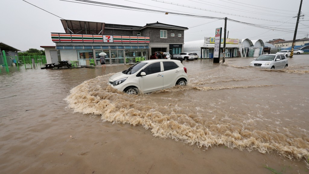 清州有車輛駛過因大雨而被淹沒的地區。路透社