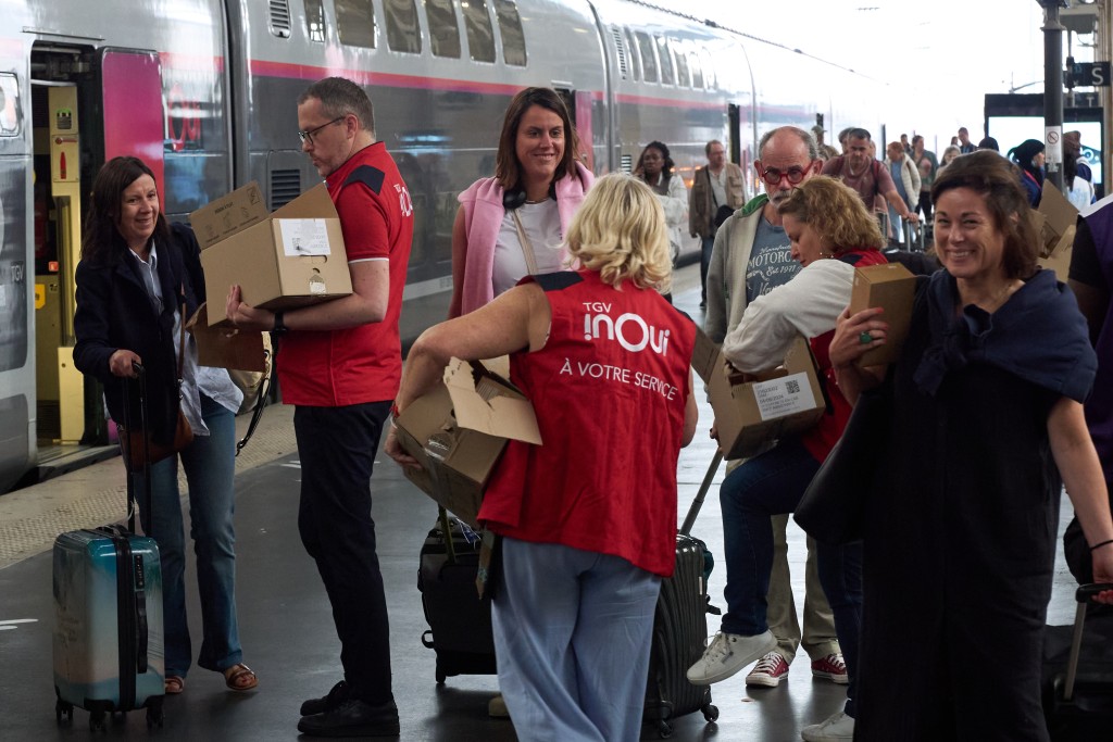法國鐵路公司工作人員向受影響旅客派發食物。新華社