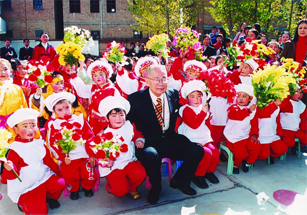 協成行方氏家族積極在中港兩地捐建學校，圖為方潤華與內地受惠學生合照。