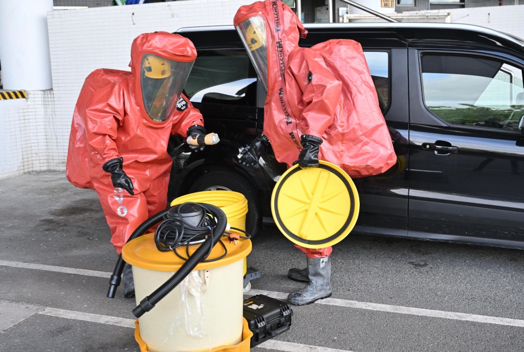 穿着化學物品保護袍的消防處人員於現場處理危害物質。政府新聞處