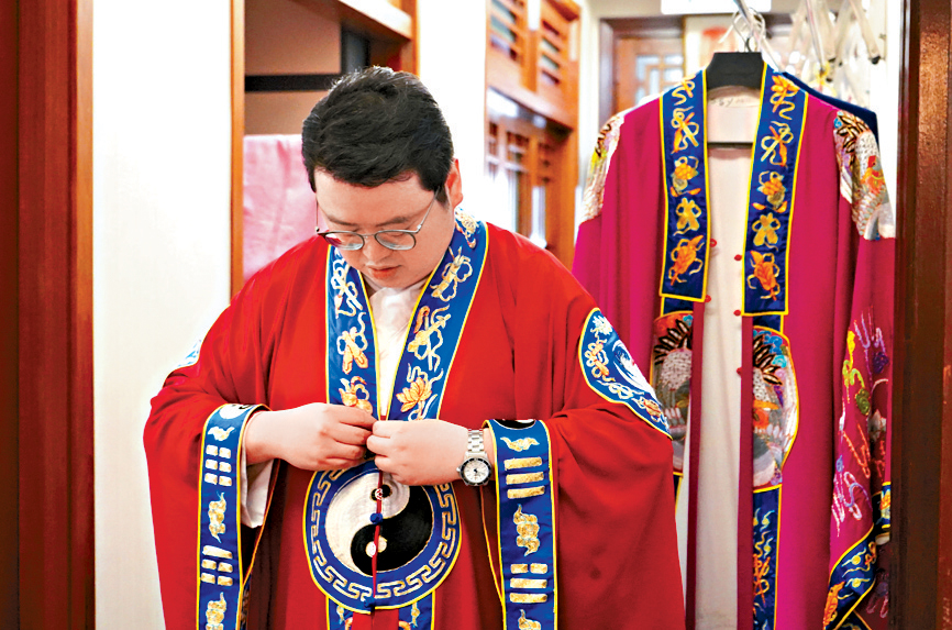 馮耀中謹慎地穿上道袍，準備參與「科儀」。