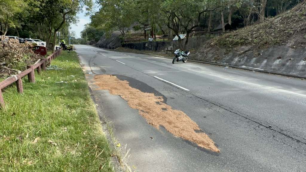 警員以木糠舖在路面吸收油迹。