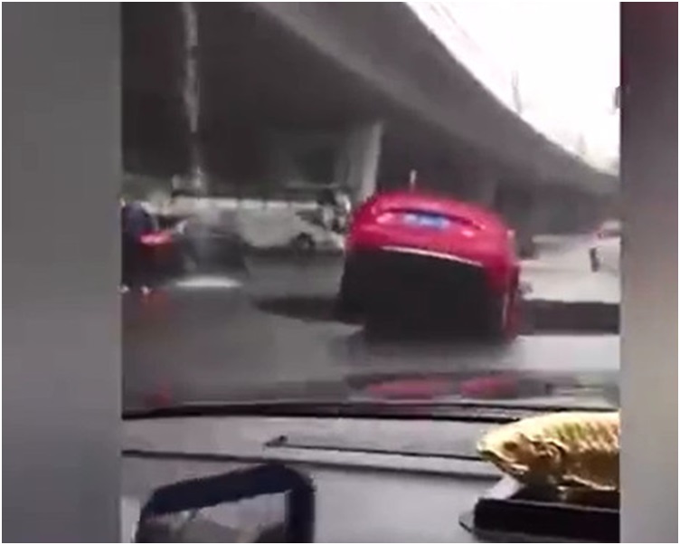 兩輛紅色私家車瞬間墜入深坑。