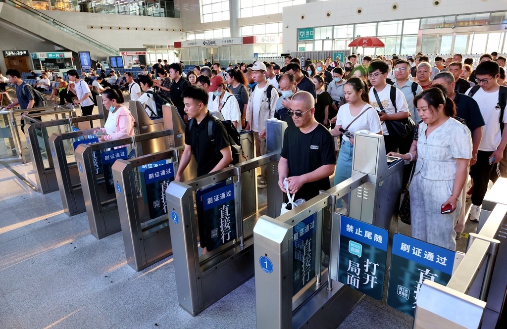 2024年7月1日，山东枣庄，旅客在铁路山东枣庄站检票过闸机。