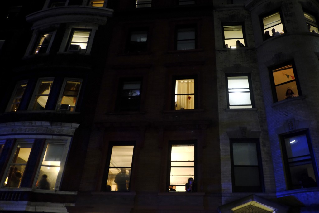 哥大宿舍學生在窗旁觀看清場情況。美聯社