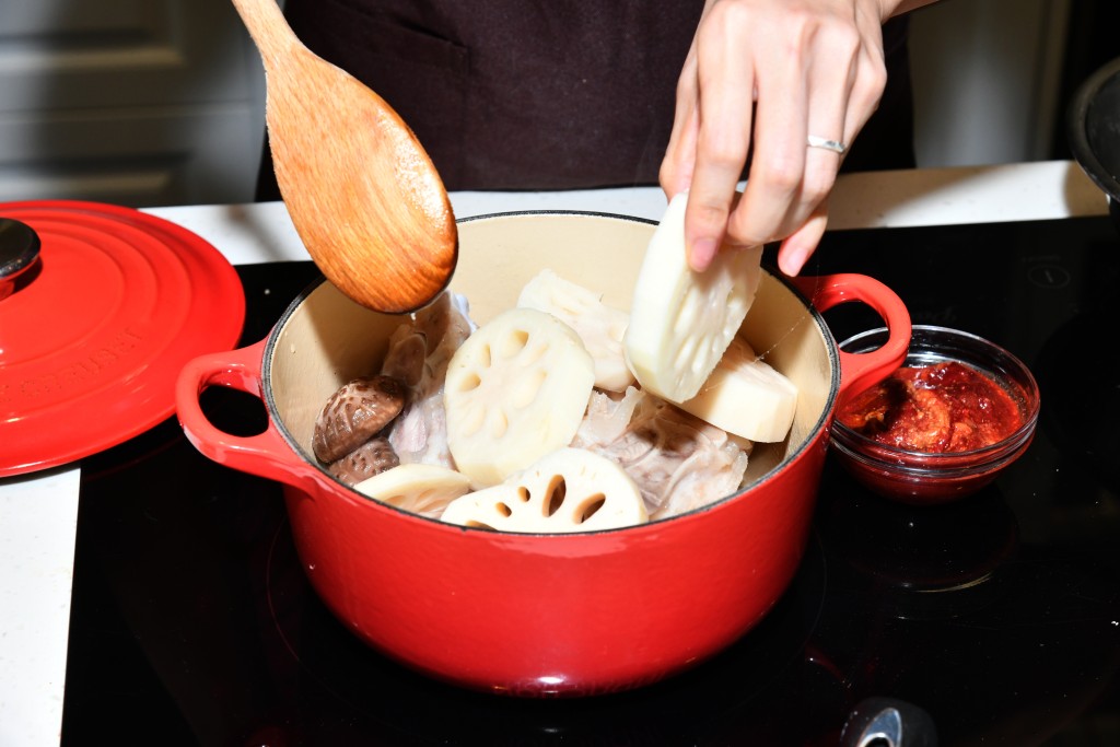 加入蓮藕、冬菇、花生和餘下調味料拌勻，下水煮滾。Add the lotus root, shiitake mushroom, peanuts and the remaining seasoning, mix well. Pour in water and bring to a boil.
