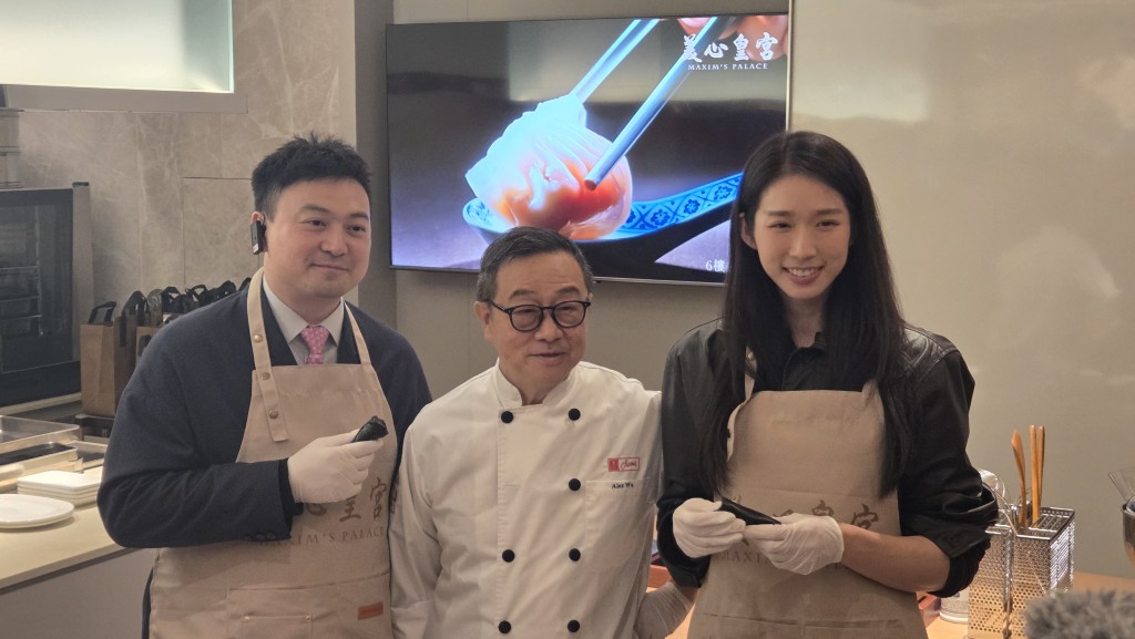 立法會議員梁進（左）及江旻憓（右）在廚師指導下，製作並品嚐黑芝麻卷。趙克平攝