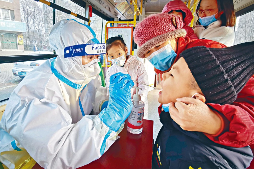 大连医务人员为一名小童作新冠病毒检测。