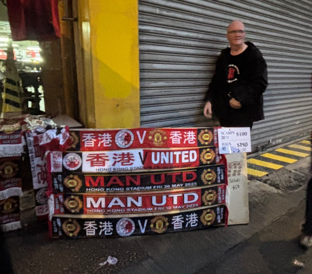 有外籍人士在銅鑼灣至大球場路上擺攤售賣香港對陣曼聯圍巾,售價100元一條。郭穎彤攝 有外籍人士在銅鑼灣至大球場路上擺攤售賣香港對陣曼聯圍巾,售價100元一條。郭穎彤攝