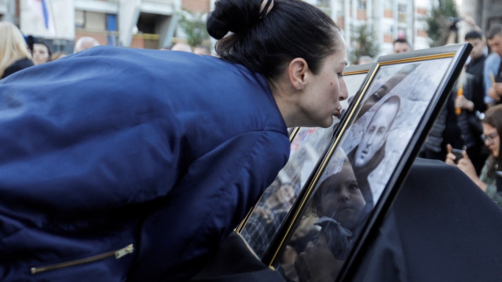 一名女子在悼念活动中亲吻遗照。  路透社