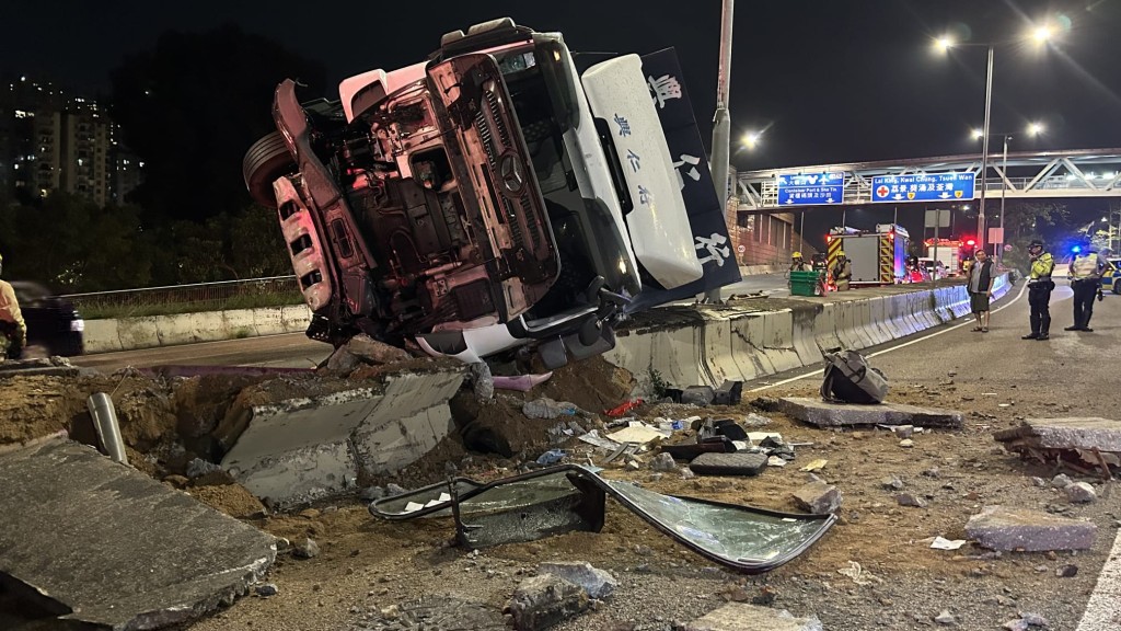 車禍現場一片狼籍，石壆碎塊滿地，貨車車頭擋風玻璃破毀脫落地上，零件四散。蔡楚輝攝
