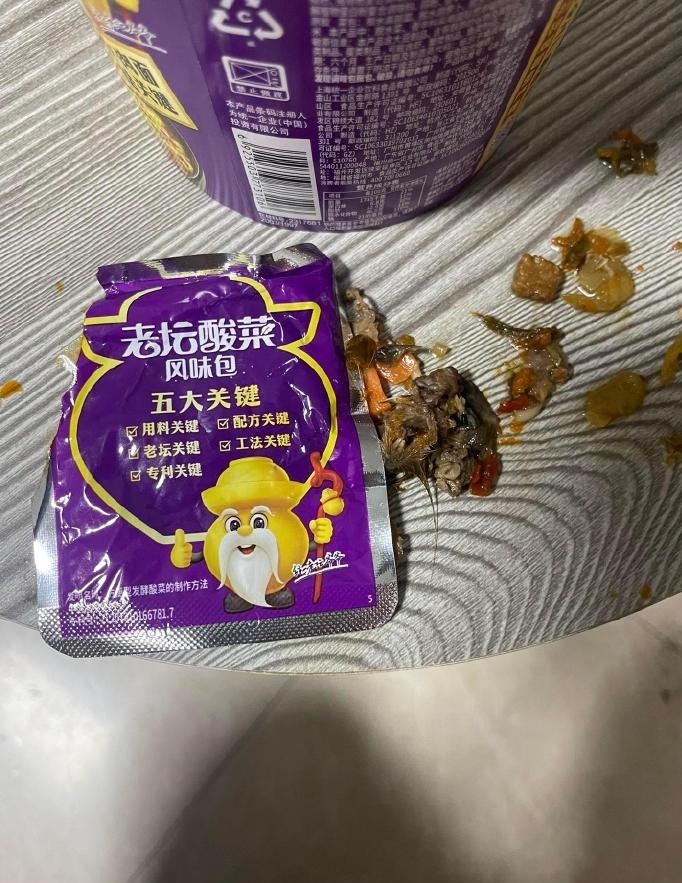 疑似有尖牙和鬍鬚的鼠頭在酸菜包裡面。