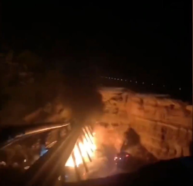 塌陷路段有汽車跌落大坑起火，冒出火光及濃煙。