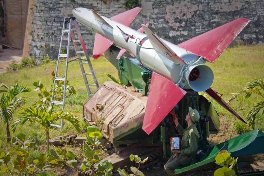 一名古巴士兵正為一枚SAM-2導彈模型塗色。1962年導彈危機期間，SAM-2是蘇聯在古巴部署的其中一款導彈。