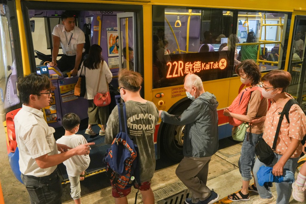 旅客搭乘免費穿梭巴士到啟德港鐵站。吳艷玲攝