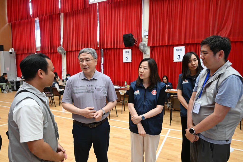 卓永興(左二)在登記中心與關愛隊義工交談。旁為民政事務總署署長杜潔麗(右二)。 卓永興(左二)在登記中心與關愛隊義工交談。旁為民政事務總署署長杜潔麗(右二)。