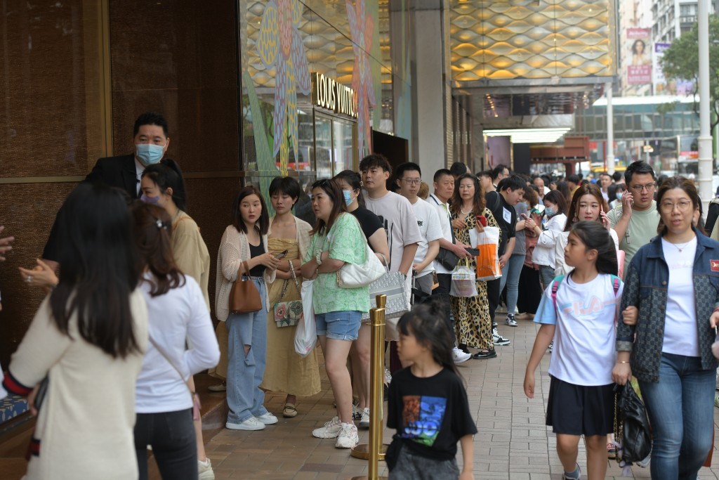 游客在名店外排队，准备选购各式奢侈品。梁誉东摄
