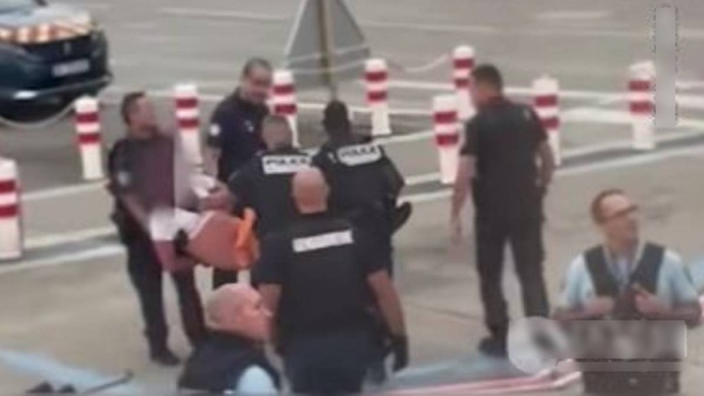 企圖打開飛機緊急艙門的醉漢被法國警方抬走。環球網