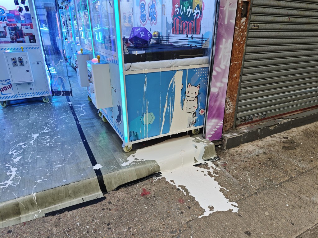 放置於門外的兩部公仔機及店內地板遭淋白油。蔡楚輝攝