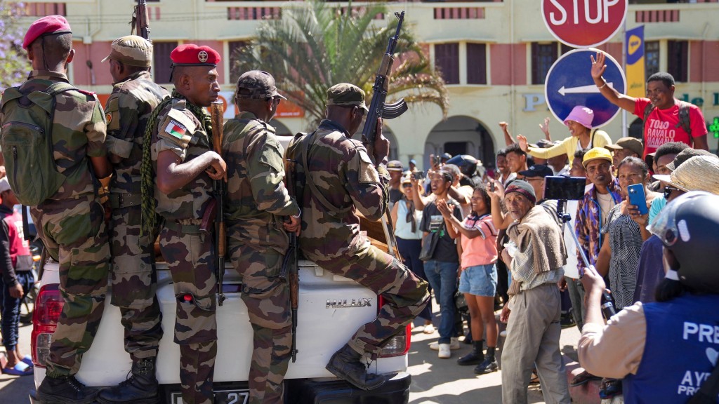 馬達加斯加民眾在島中心悼念反政府示威者的民眾向士兵致敬。美聯社 馬達加斯加民眾在島中心悼念反政府示威者的民眾向士兵致敬。美聯社