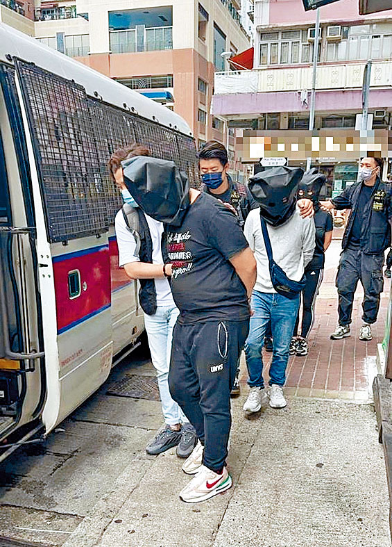 警員將多名被捕人士帶上警車。