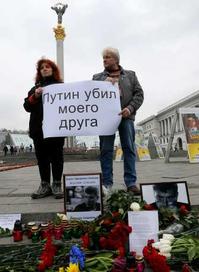 烏克蘭人舉著「普京殺了我的朋友」標語。美聯社