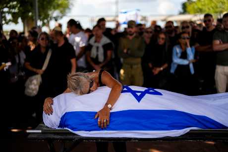 在以色列特拉维夫附近一个公墓，一名母亲伏在遭哈马斯杀害的儿子遗体上哭泣。美联社