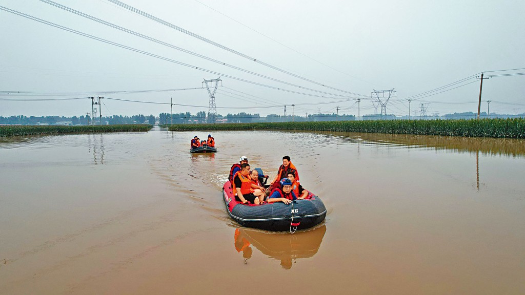河北涿州村民坐橡皮艇离开被淹的家乡。