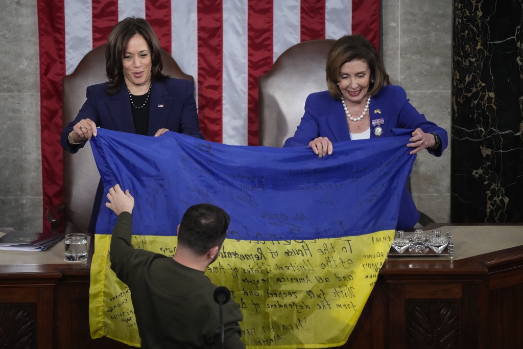 贺锦丽和佩洛西接过这份礼物，然后一同把附有军人签名的乌克兰国旗张开。AP
