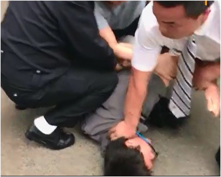 該名攝記被便衣警員壓在地上。now電視截圖