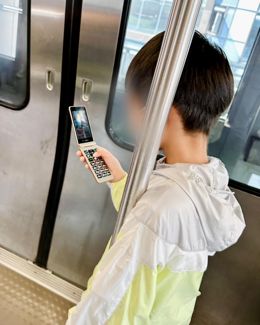 台灣一名男童則在使用舊款摺疊式電話。「楊元慶 無法取代的溜溜球」FB