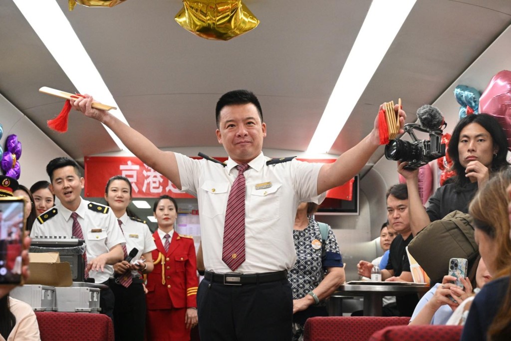 在前往北京西的首發列車上，車務人員為乘客表演。「運輸及物流局」fb圖片