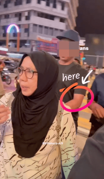 男子突然伸手進包取出女子背囊內的錢包。