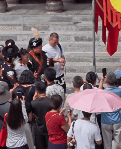 洪金寶需要工作人員攙扶。