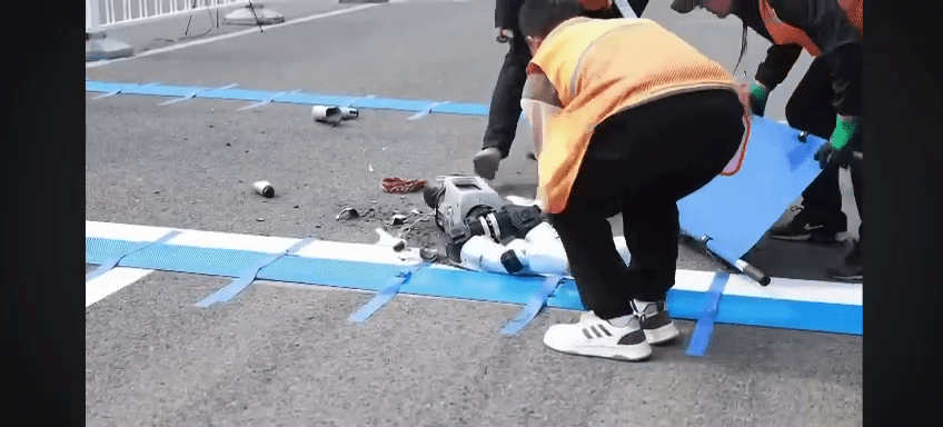 工作人員用擔架將機械人抬走。