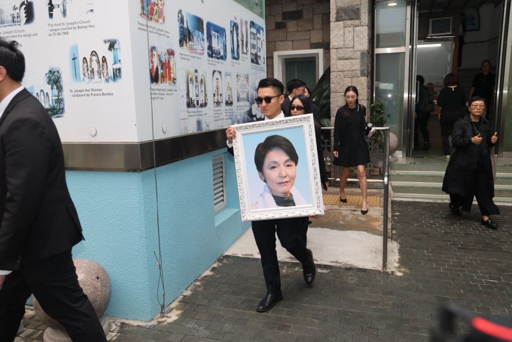 谷薇麗兒子林世晞捧著遺照。