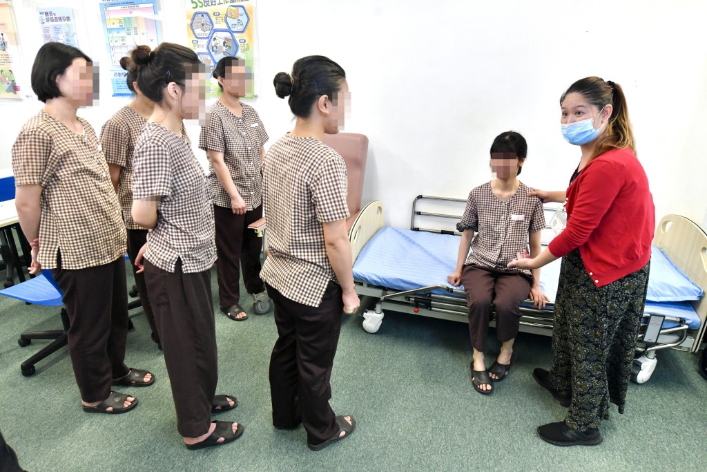 導師向女學員講解如何照顧長者及病患人士。 盧江球攝 導師向女學員講解如何照顧長者及病患人士。 盧江球攝