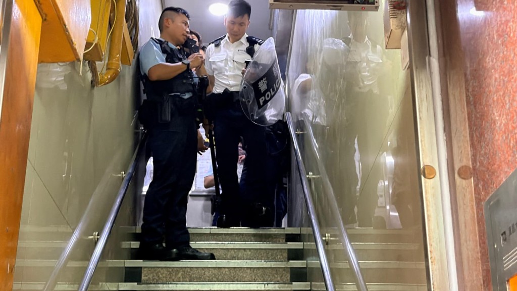 手持盾牌的警员在一座大厦内进行搜索。
