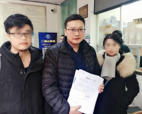 受害人邓世平家属和代理律师周兆成（中）。（网图）