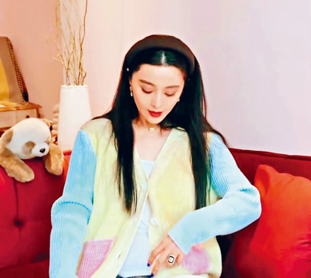 冰冰发现露出肚凸凸后，即以礼物作遮挡。