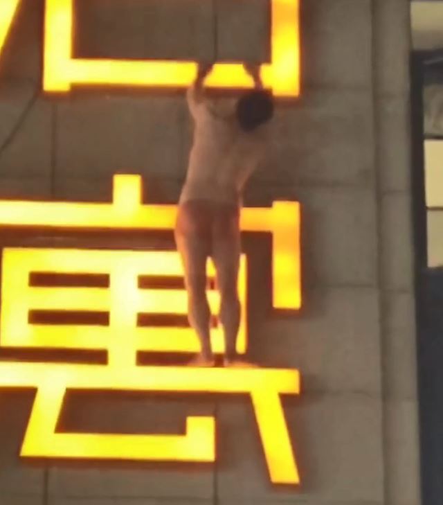 男子雙手抓住廣告牌。微博