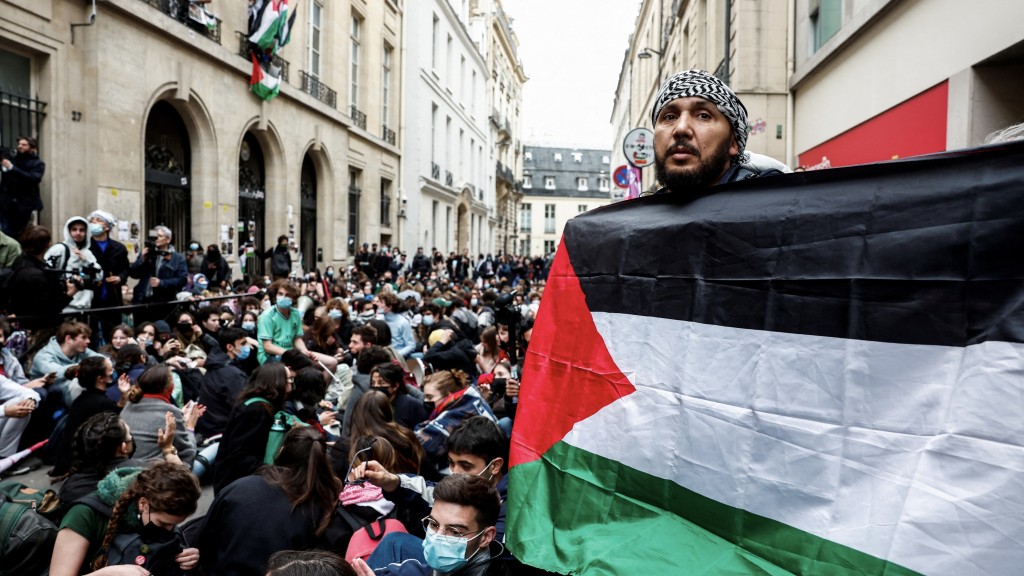 年轻人占领巴黎政治大学大楼前的一条街道，对加沙的巴勒斯坦人表达支持。  路透社