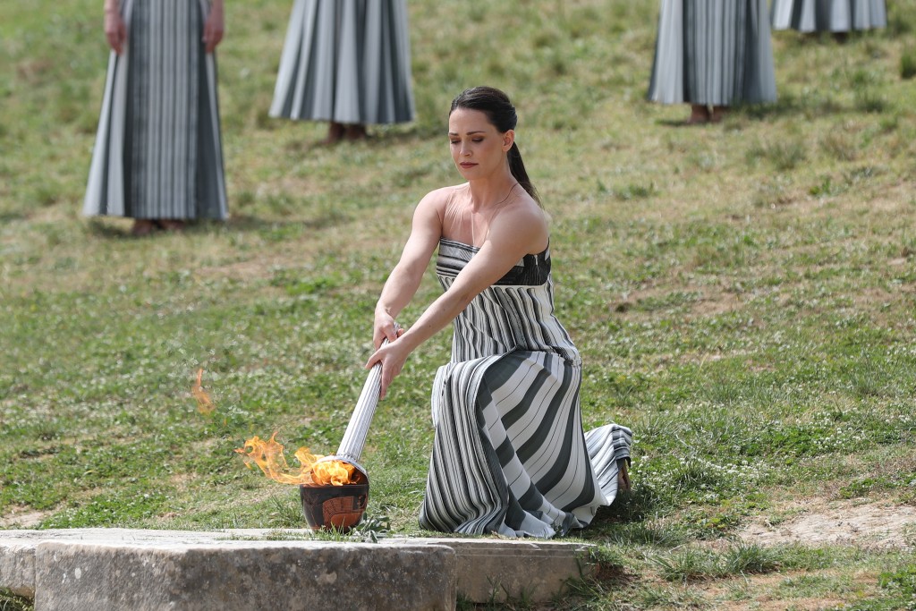 扮演最高女祭司的演员玛丽·米娜点燃火炬。 新苹社