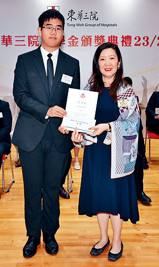 甲辰年主席鄧明慧女士（右）頒發「東華三院153周年獎學金」予得獎生朱汶謙（左）。
