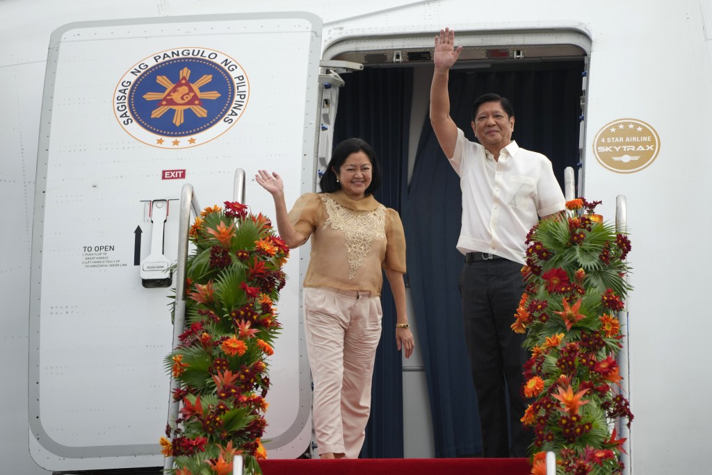 在菲律宾马尼拉的维拉莫尔空军基地，菲律宾总统小马可斯（右）与妻子登上飞往中国的飞机。AP