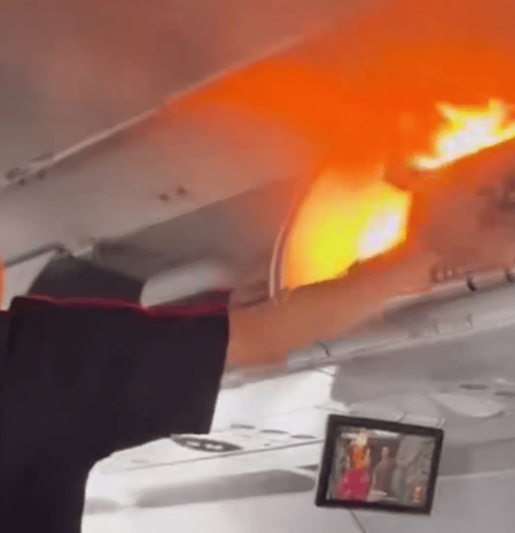 飛機客艙行李架上出現了明火。 飛機客艙行李架上出現了明火。
