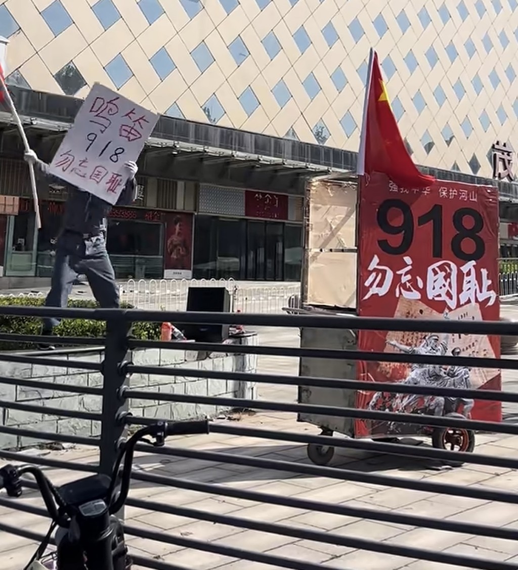 山東54歲男在街頭揮舞國旗。抖音@淄博馮老師