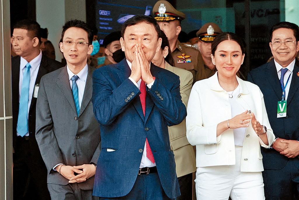 他信(中)上周二結束流亡回國，抵達曼谷廊曼機場，子女到場迎接。