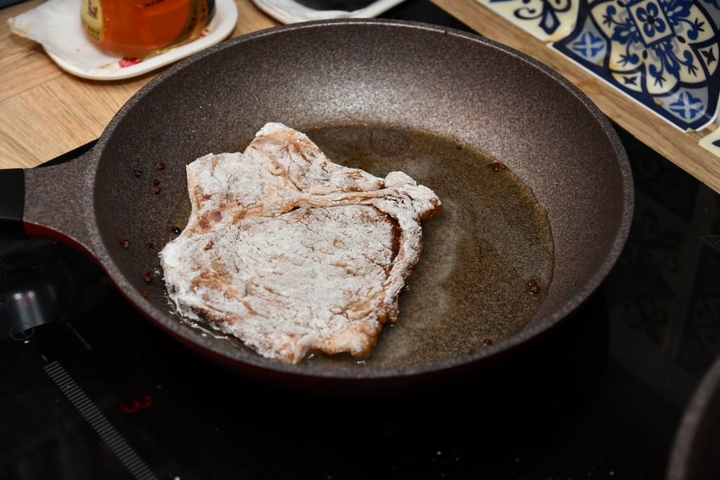 鑊中燒油四湯匙，豬扒煎至金黃及熟透，撈起。Heat 4 tbsp oil in a pan, add the pork chops and fry until golden brown and cooked. Remove.