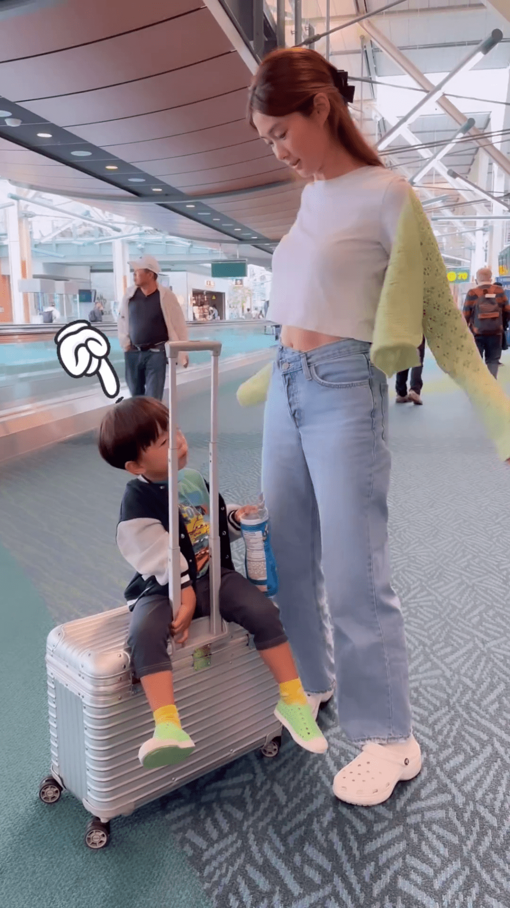 岑丽香上载一段机场影片，其间脱下外套。